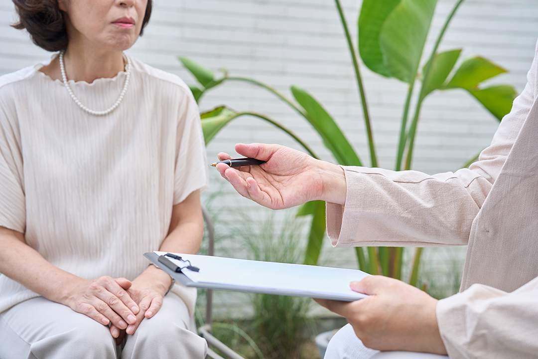 기록지를 들고 있는 사람과 대화하는 사진