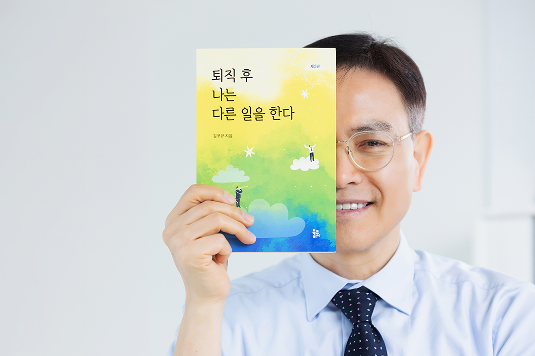 김부규 작가가 자신이 쓴 책을 들고 있다