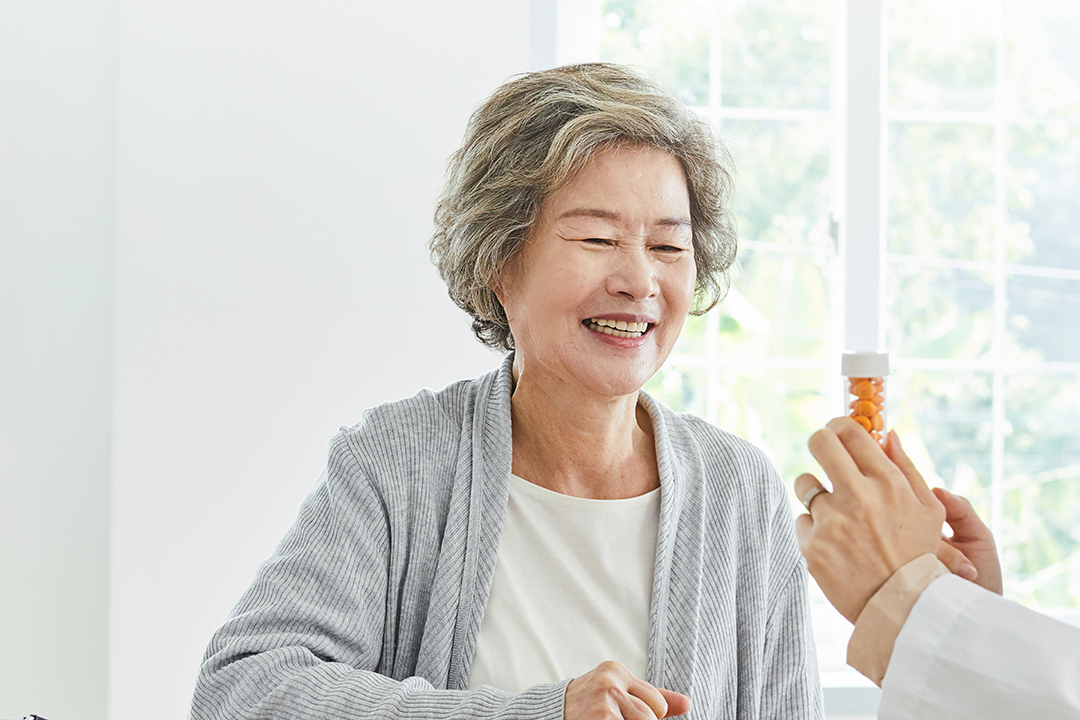 약병을 보며 웃고 있는 사람